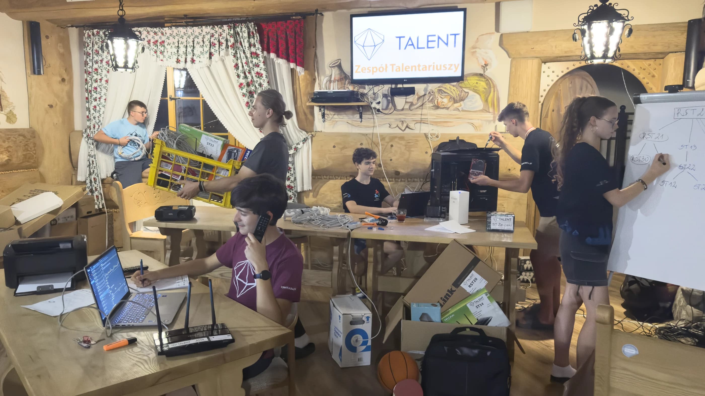 Talentariusze przygotowują sprzęt, sieć i stanowiska podczas wydarzenia Stowarzyszenia TALENT